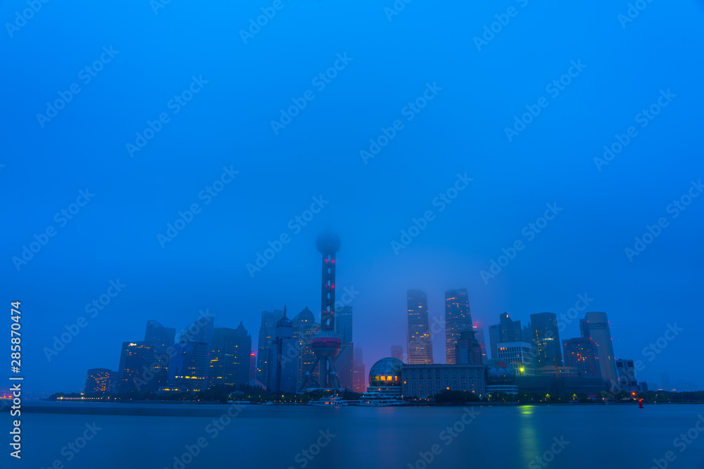The modern buildings of Lujiazui and Huangpu river with sunrise glow in Shanghai, China.