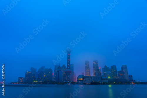 The modern buildings of Lujiazui and Huangpu river with sunrise glow in Shanghai, China.