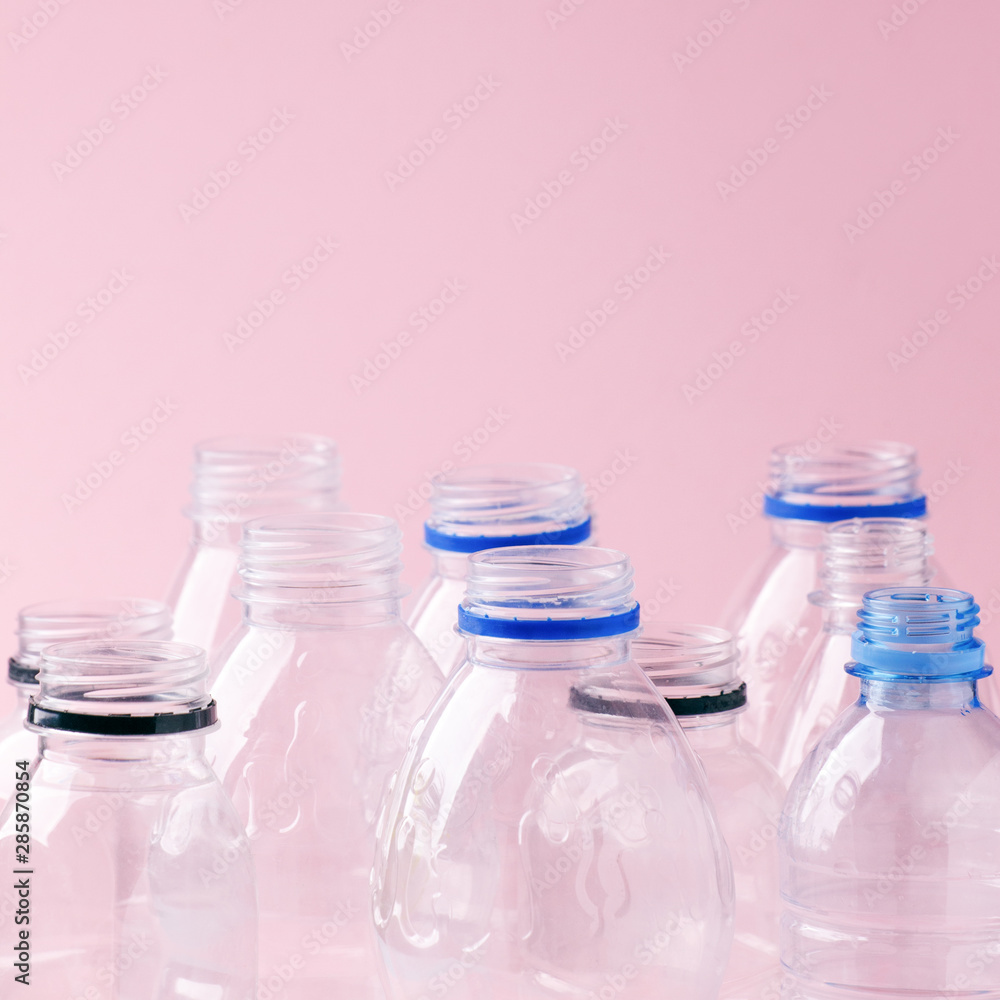 Set of empty plastic water bottles on pink background, chemical industry, eco recycle plastic material, zero waste concept, plastic ban Set of empty plastic water bottles on pink background, chemical industry, eco recycle plastic material, zero waste concept, plastic ban