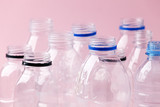 Set of empty plastic water bottles on pink background, chemical industry, eco recycle plastic material, zero waste concept, plastic ban