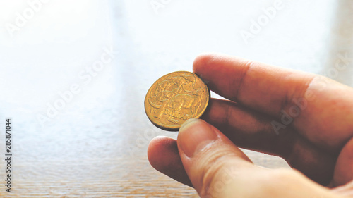 Close the Holding Australian Dollars Coin on Hand and Finger photo