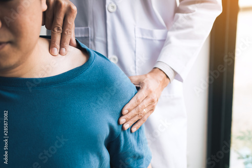 Physical therapists are using their hands to press the clavicle of the patient.