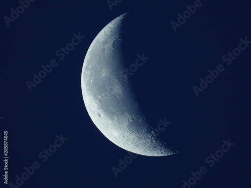Schilderij op canvas in the blue morning sky stands the waning quarter moon
