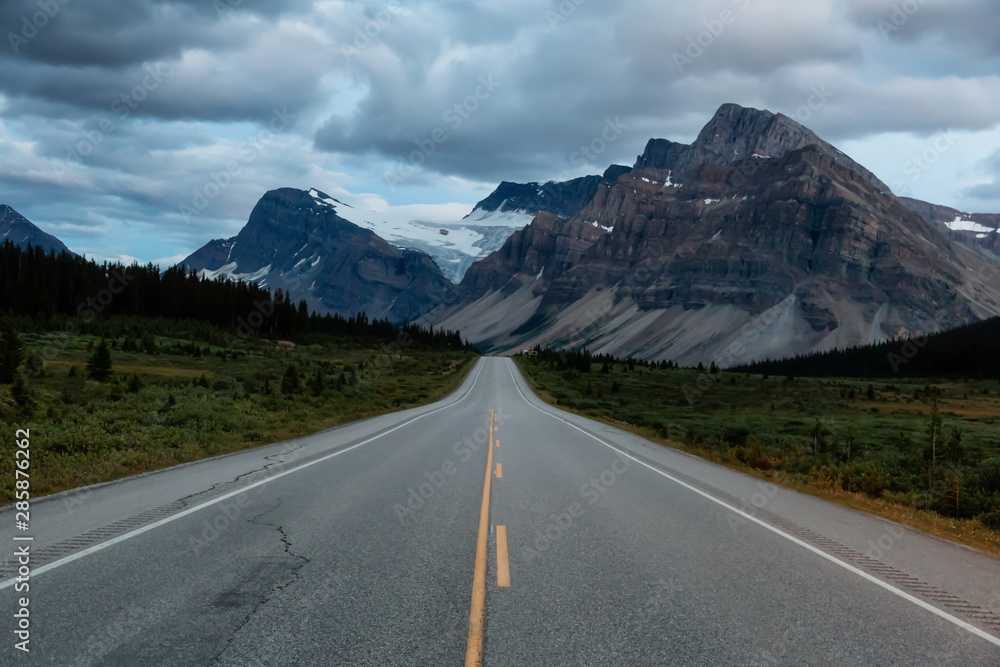 Naklejka premium Scenic road in the Canadian Rockies during a vibrant cloudy sunset. Taken in Icefields Parkway, Banff National Park, Alberta, Canada.