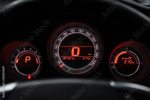 close-up of round dashboard, speedometer and tachometer with white backlight. modern car interior. © Виталий Сова