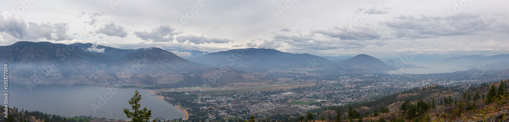Panoramic view of Penticton City during a cloudy and smokey summer morning. Taken in Skaha Bluffs Provincial Park, British Columbia, Canada.