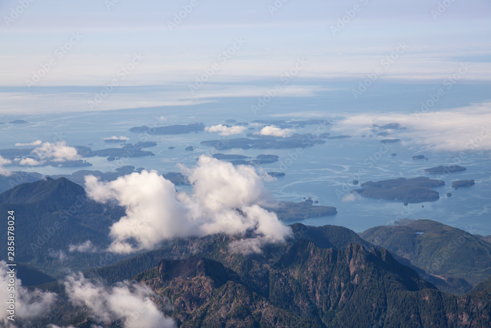 Aerial Landscape View of Beautiful Coastal Mountains on the Pacific Ocean Coast during a sunny summer morning. Taken near Tofino and Ucluelet, Vancouver Island, British Columbia, Canada. Aerial Landscape View of Beautiful Coastal Mountains on the Pacific Ocean Coast during a sunny summer morning. Taken near Tofino and Ucluelet, Vancouver Island, British Columbia, Canada.