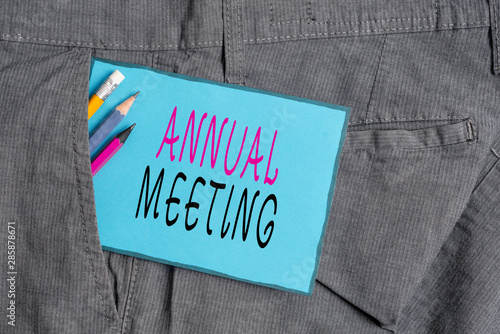 Conceptual hand writing showing Annual Meeting. Concept meaning yearly meeting of the general membership of an organization Writing equipment and blue note paper in pocket of trousers