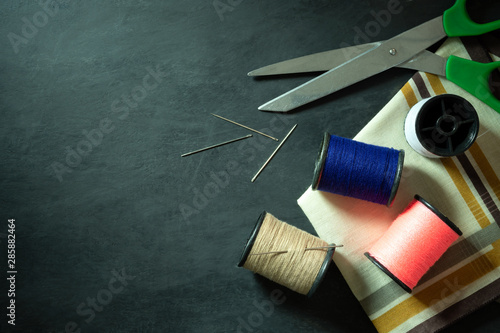 Sewing tools and equipment on black cement floor. Top view and copy space for text. Concept of tailor or fashion designer.