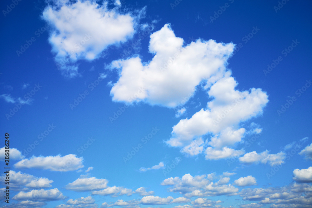 White beautiful fluffy clouds on blue sky background. The blue sky concept White beautiful fluffy clouds on blue sky background. The blue sky concept