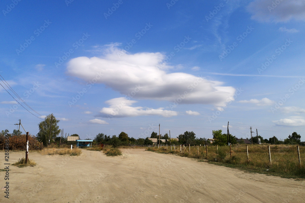 Obraz premium Beautiful scenery. Cloud an unusual on the horizon. Blue sky and sandy road