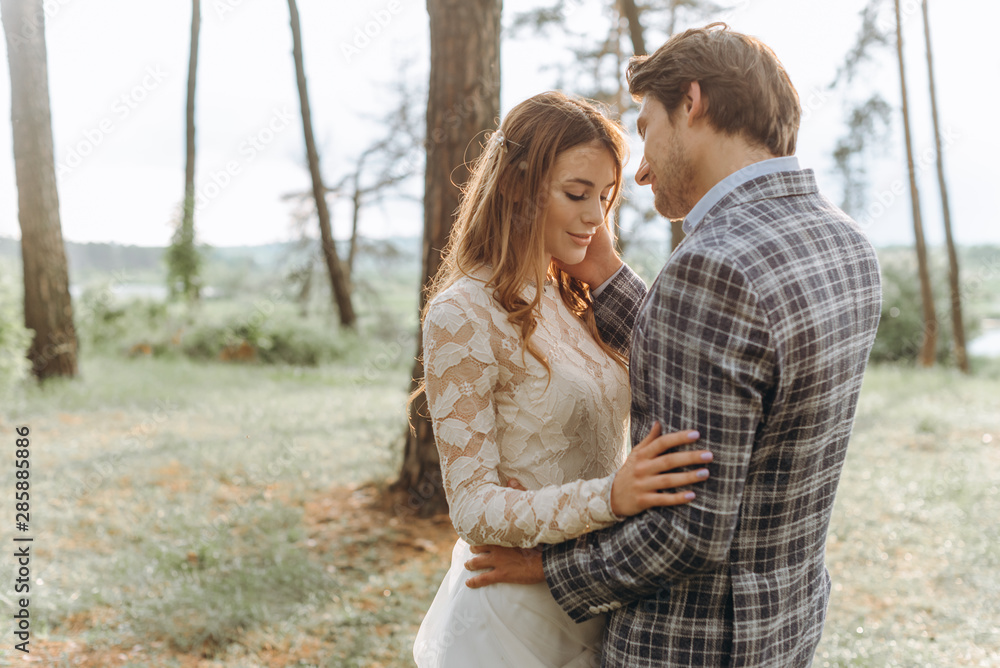 Fototapeta premium A young couple of brides walking in the pine forest