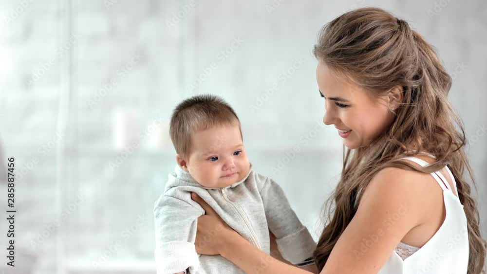 Happy woman playing with cute child smiling having fun together surrounded by natural light Happy woman playing with cute child smiling having fun together surrounded by natural light