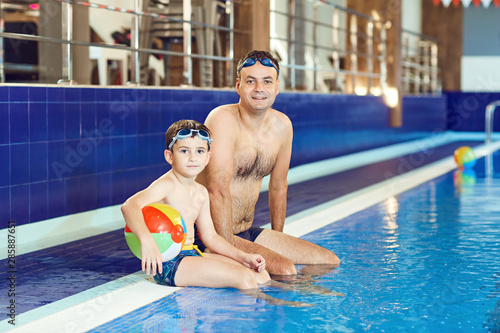 Father and son swim in a swimming pool