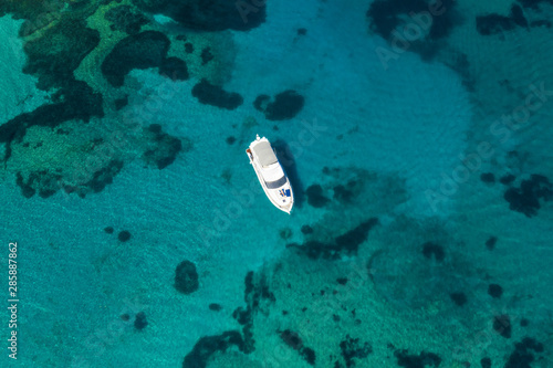 View from above, stunning aerial view of a luxury yacht floating on an emerald green bay of water in Sardinia. Maddalena Archipelago National Park, Sardinia, Italy...