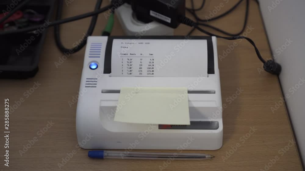 Thermal printer on messy desk prints summary of coin counting done by automatic coin counter. Thermal printer on messy desk prints summary of coin counting done by automatic coin counter.