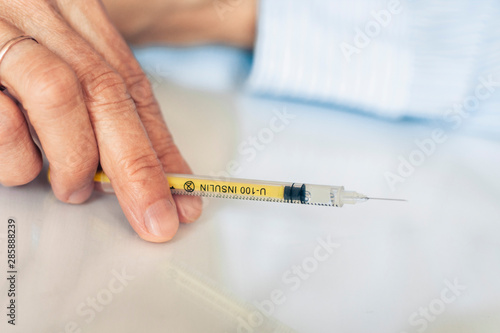 Pile of medical syringes for insulin for diabetes in woman hand.