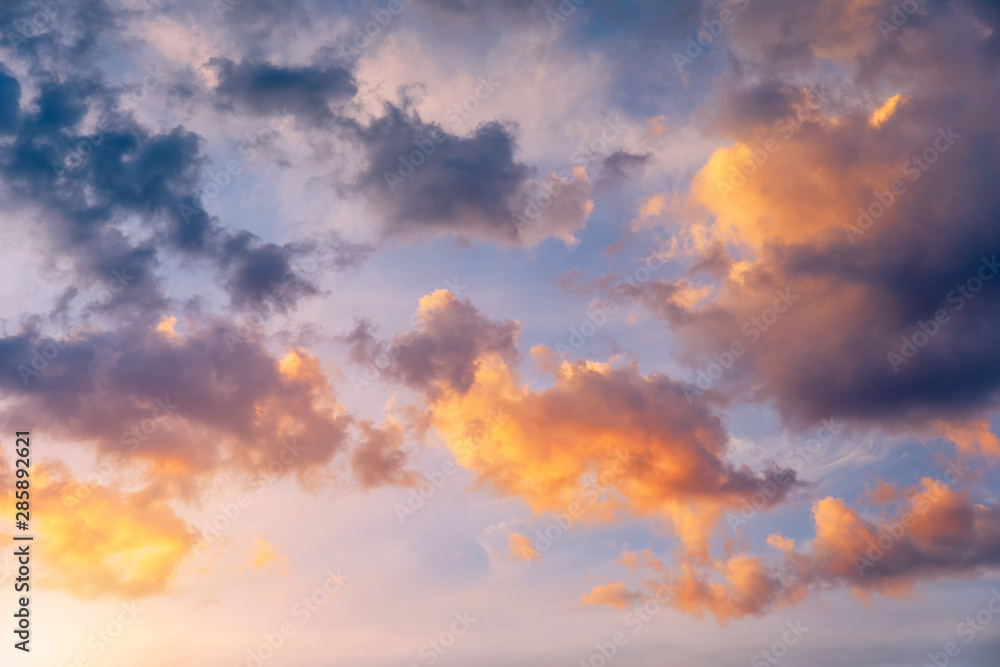 Beautiful sunset sky above clouds with dramatic light. Sunset sky for background, sunrise sky and clouds. Bright orange and blue sky and light of the sun. Beautiful sky with cloud before sunset.