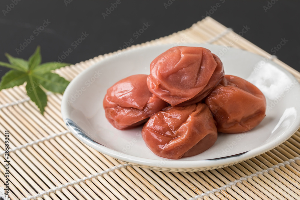 竹のすだれに敷いてある日本食の美味しいそうな梅干しと紅葉 竹のすだれに敷いてある日本食の美味しいそうな梅干しと紅葉