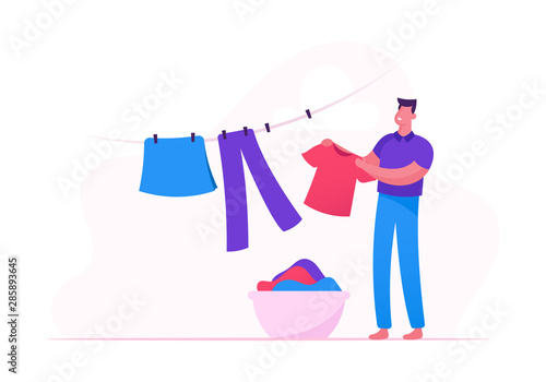 Young Man Hanging Clean Wet Clothes on Rope Taking Washed Linen from Basket in Bathroom or Laundry