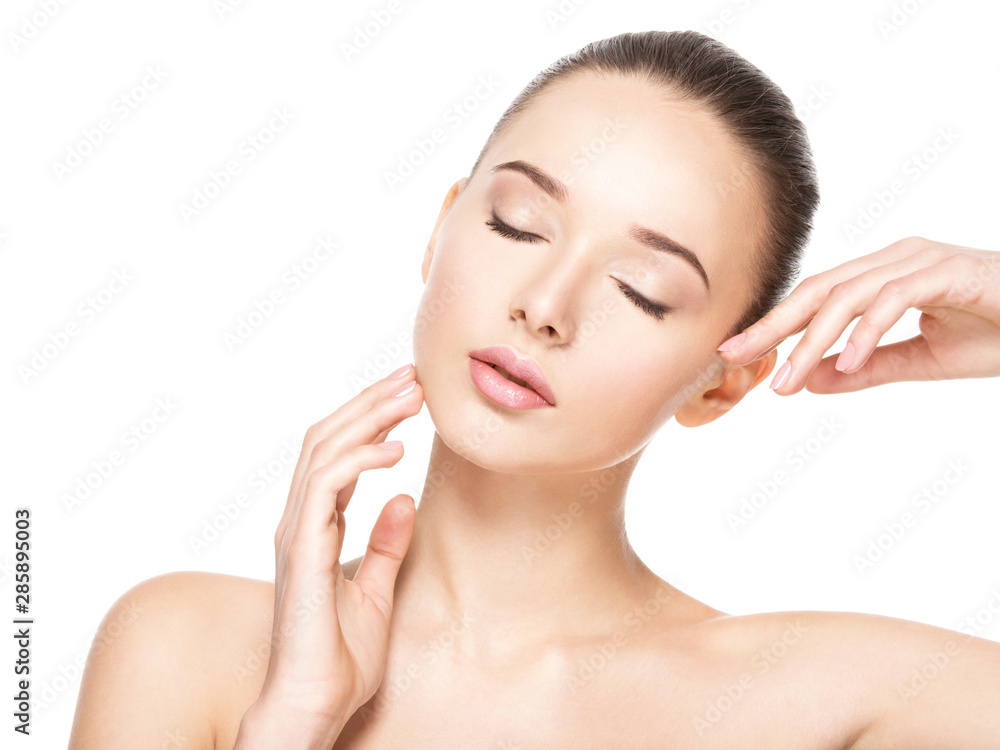 Young woman with healthy clean skin touches the face. Skin care concept.