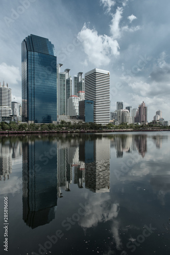 Skyline of Bangkok with Water or Lake in the foreground and big Clouds in the Sky