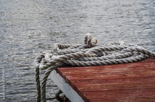 The rope lies on the pier against the background of water © Макар Мосин