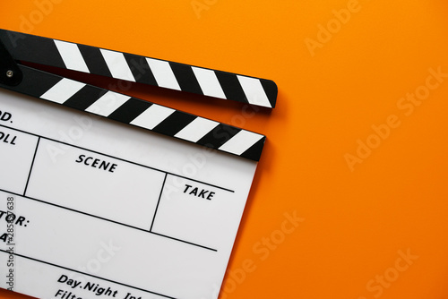 Obraz na plátně movie clapper on orange color table ; film, cinema and video photography concept