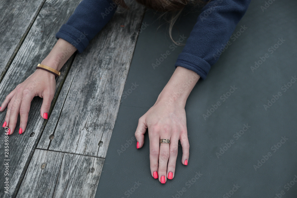 Women's hands on a background of blue yoga mat