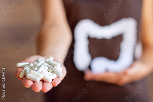Female hand is holding capsules with bifidobacteria and lactobacilli. Young woman takes pills for her health. Preparations that promotes good digestion and functioning of gastrointestinal tract. photo