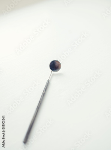 Dentist tools or instruments in dental office: dental mirror on white background. © jozzeppe777