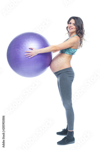 Portrait of a beautiful young pregnant woman exercises with fitball. Working out and fitness, pregnancy concept. Isolated white background. © satyrenko