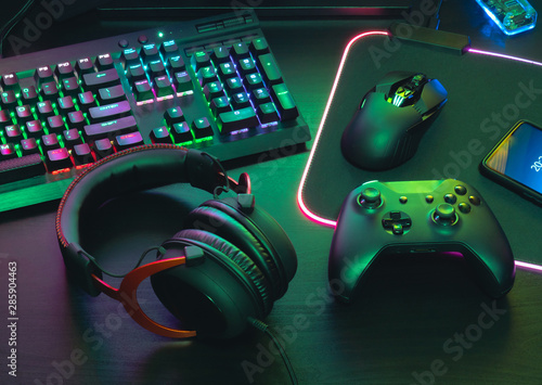 Fotografie, Obraz gamer work space concept, top view a gaming gear, mouse, keyboard, joystick, headset, mobile joystick, in ear headphone and mouse pad on black table background