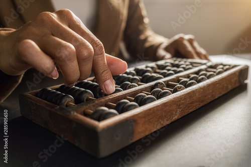 Asian woman hands accounting with old abacus. Financial design concept. photo