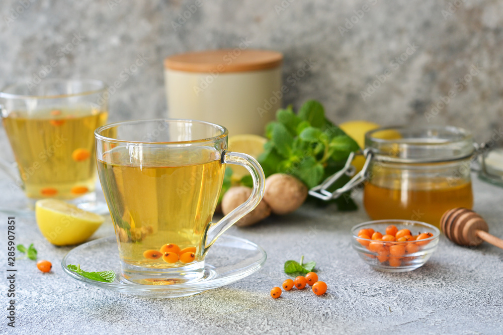 Tea with mint and sea buckthorn on a concrete background with space for text. Advertising. Tea with mint and sea buckthorn on a concrete background with space for text. Advertising.