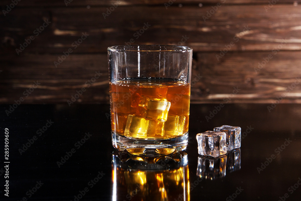 whiskey with ice on a wooden table