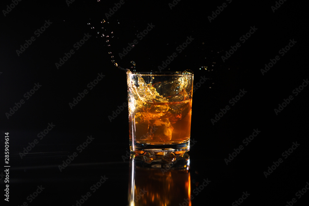 Shot of whiskey with splash on black background Shot of whiskey with splash on black background