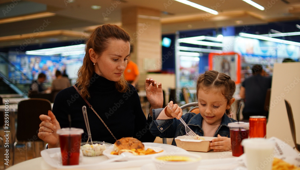 Cute little girl with young mother in restaurant Cute little girl with young mother in restaurant