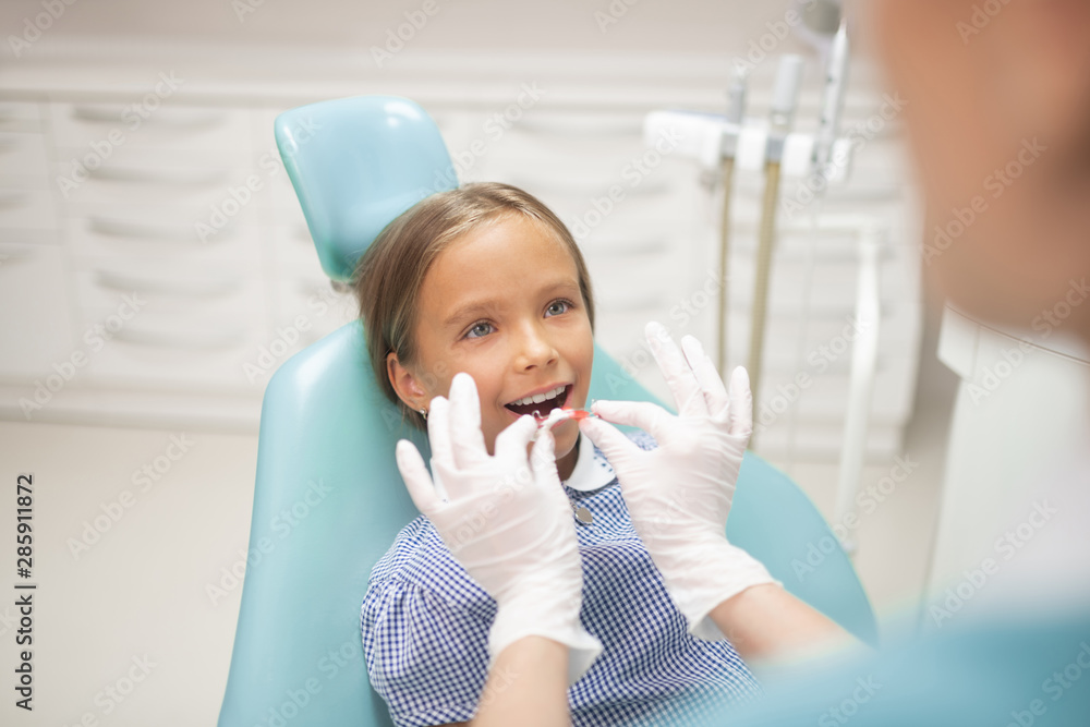 Girl opening mouth while dentist putting mouth guard Girl opening mouth while dentist putting mouth guard