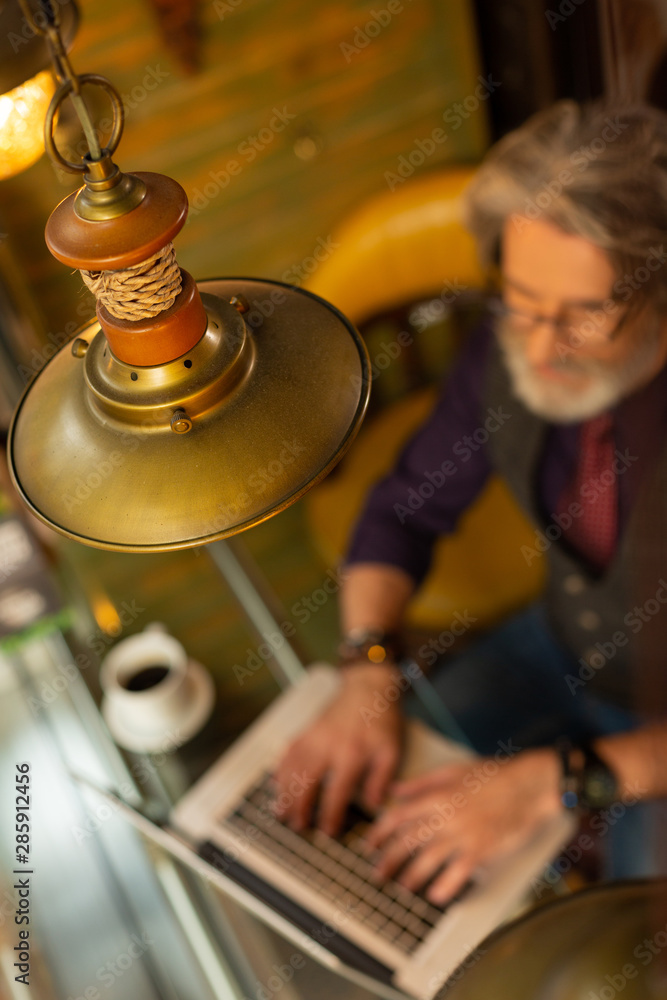 Obraz premium Man working in a cafe with specific interior.