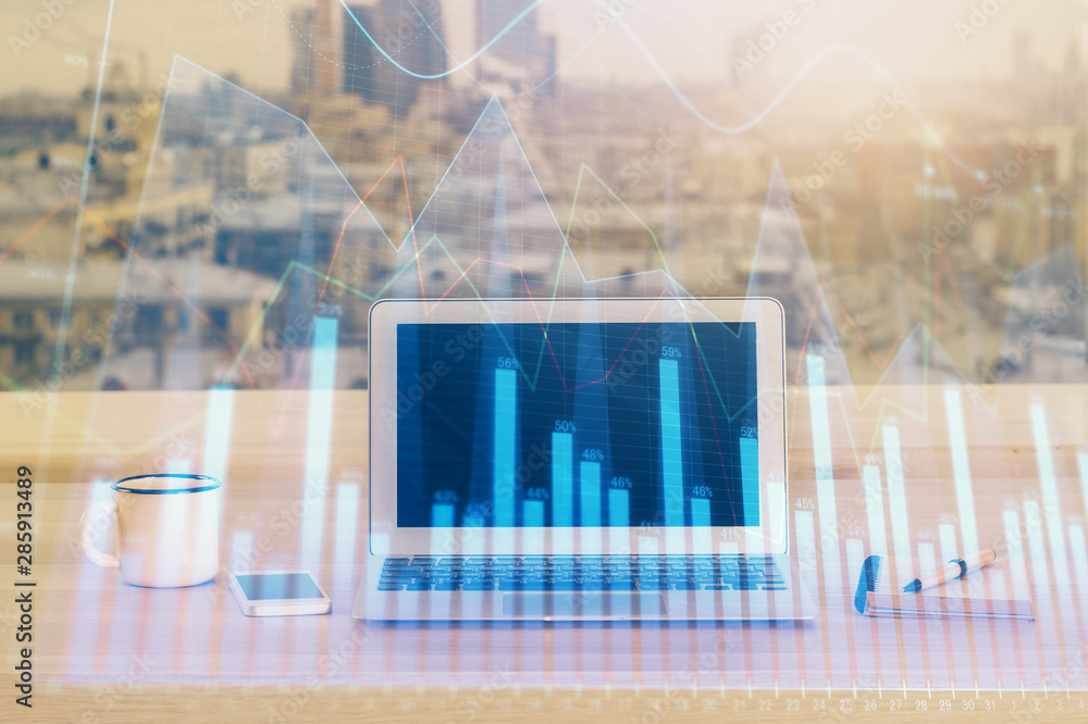 Financial chart drawing and table with computer on background. Double exposure. Concept of international markets. Financial chart drawing and table with computer on background. Double exposure. Concept of international markets.