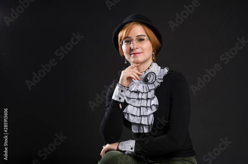 The retro porteit of a pretty young woman in black dress and hat photo