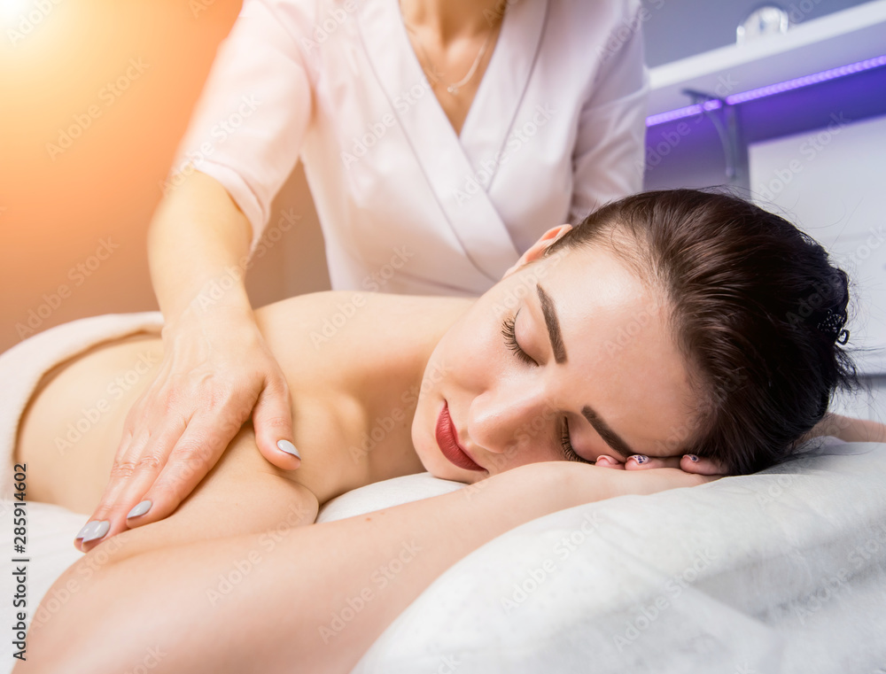 Beautiful young woman enjoying massage in spa salon. Cosmetology Beautiful young woman enjoying massage in spa salon. Cosmetology