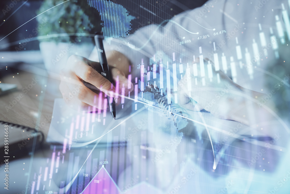 Financial forex graph displayed on hands taking notes background. Concept of research. Double exposure Financial forex graph displayed on hands taking notes background. Concept of research. Double exposure