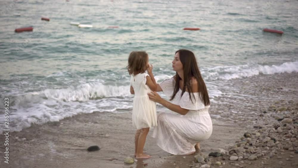 mother with a small daughter, in white dresses, walk, run, fun, sea shore, evening mother with a small daughter, in white dresses, walk, run, fun, sea shore, evening