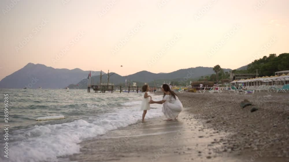 mother with a small daughter, in white dresses, walk, run, fun, sea shore, evening mother with a small daughter, in white dresses, walk, run, fun, sea shore, evening