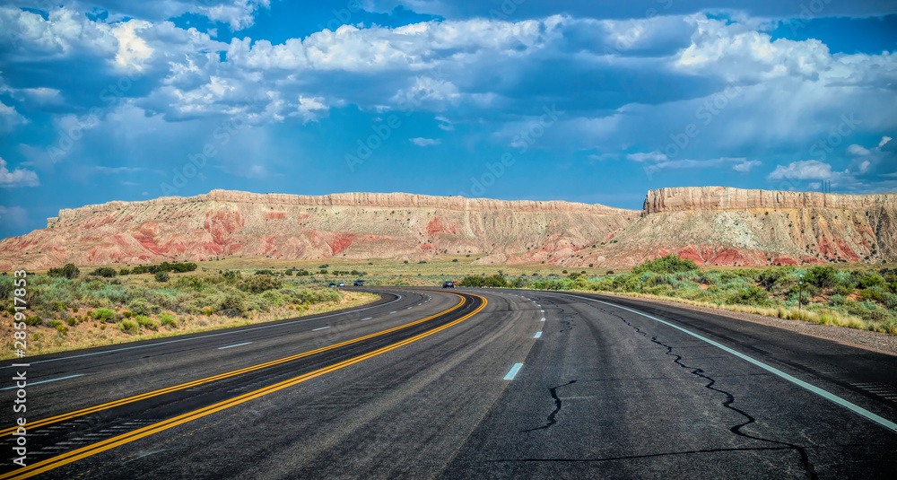 Obraz premium Arid landscape of Arizona. The crumbling sandstone mountains and the highway 
