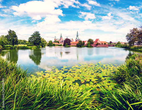 Photography magical fascinating landscape with lake and largest renaissance castle in Scandinavia Frederiksborg slot Castle near Copenhagen