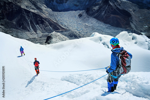 Fototapeta Group of climber descending after mountain summit peak enjoying the landscape view