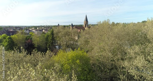 Paray-le-Monial basilica appearing behind trees, France